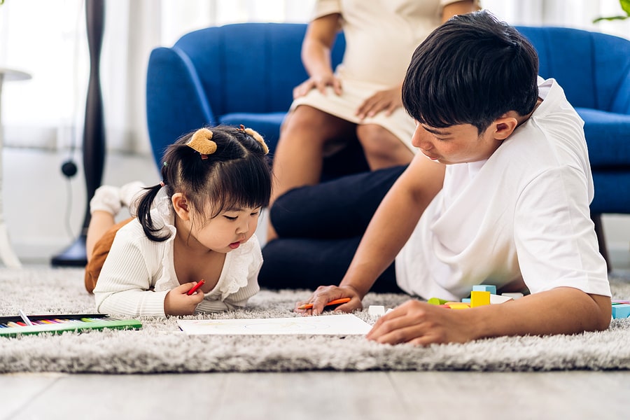 Dad and daughter coloring on floor