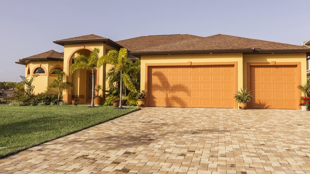 A luxury single-family home with a newly finished asphalt shingle roof and a paved driveway, representing a typical residential project that factors into a Jacksonville roof permit cost estimate.